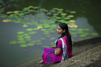 Woman in Pink Sari Dress Sitting on Stair Beside Body of Water