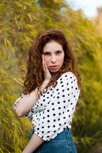 Woman in Polker Dots Top Holding Her Face