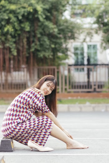 Woman in Printed Dress Sitting Down
