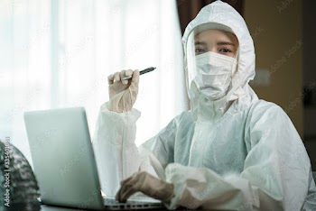 Woman in protective hazmat suit worker  in laboratory computer analyzing in laboratory. to stop spreading  coronavirus or COVID-19.