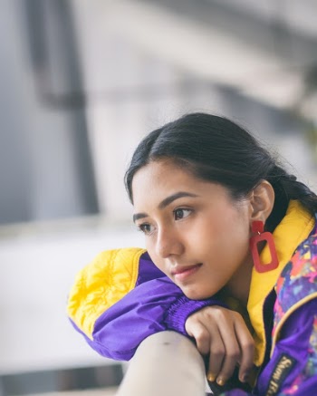 Woman In Purple And Yellow Jacket Facing Sideways