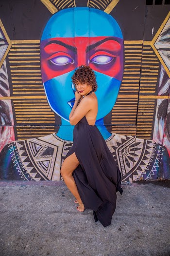 Woman in Purple Maxi Dress Posing In front Of A Wall With Mural