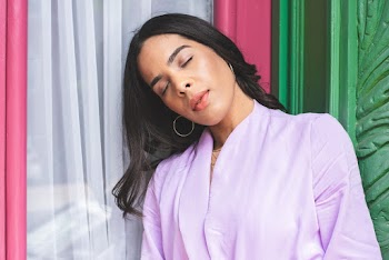 Woman in Purple Robe leaning on a Glass Window