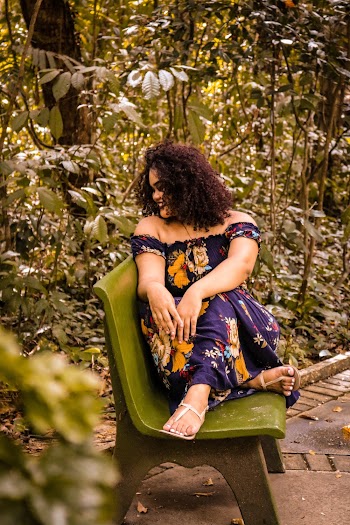 Woman in Purple, Yellow, and Green Floral Dress Sitting on Green Bench