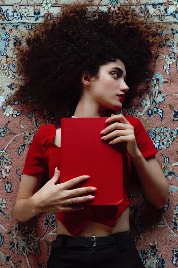 Woman in Red and White Floral Shirt Holding Red Book · Free Stock Photo