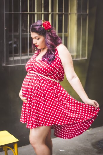 Woman in Red and White Polka Dots Mini Dress Holding Her Stomach