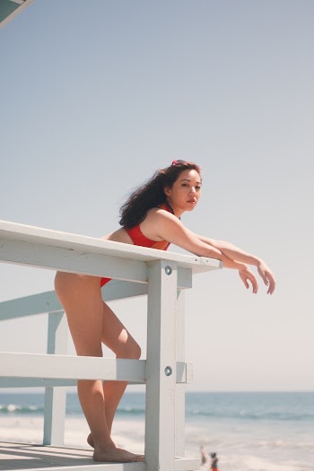 Woman in Red Bikini Leaning on Lifeguard Tower