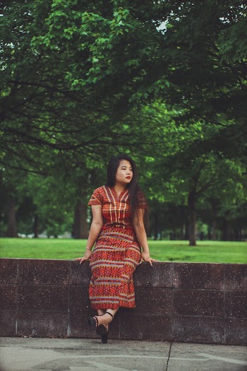 Woman in Red Dress Sits on Concrete Fence