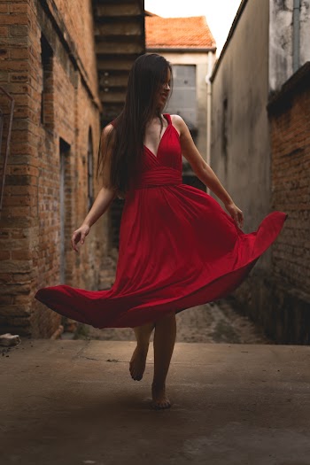 Woman in Red Dress Standing on Alley
