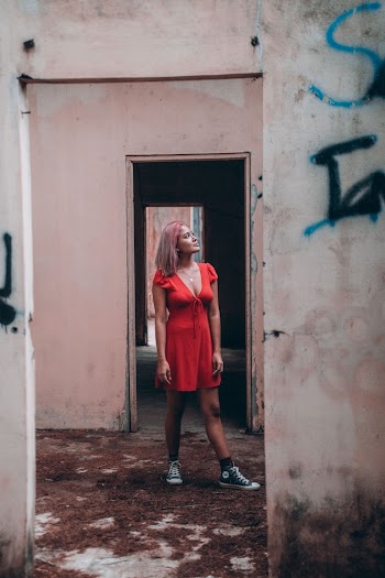 Woman in Red Dress Standing on Wrecked Building