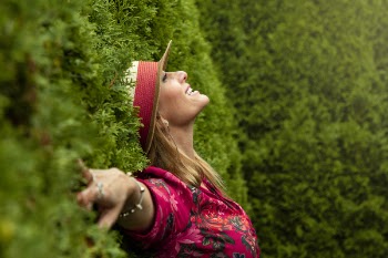 Woman in Red Floral Shirt Lying on Grass Field