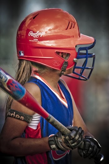 Woman in Red Helmet Swinging Wooden Bat