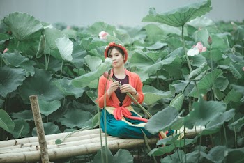 Woman in Red Jacket Sitting Near Plants