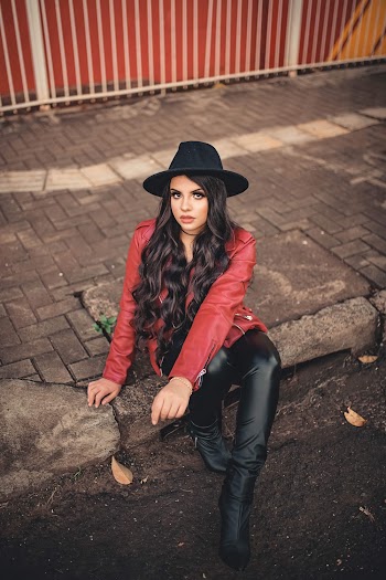 Woman in Red Leather Jacket Sitting on Pavement