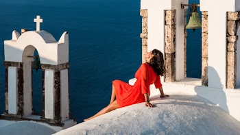 Woman in Red Long-sleeved Dress Sitting On White Concrete Building