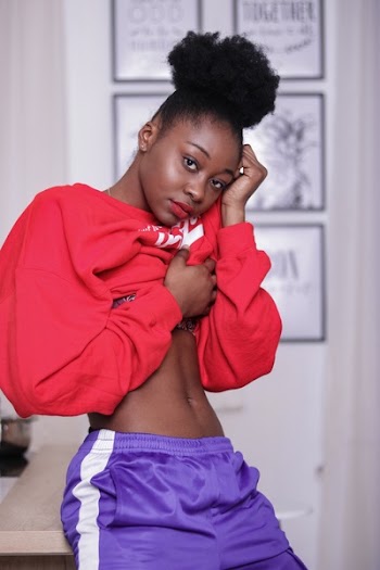 Woman in Red Long-sleeved Shirt and Purple and White Bottoms Sitting on Beige Surface