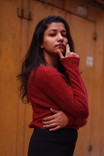 Woman in Red Long-sleeved Shirt Standing Beside Wall