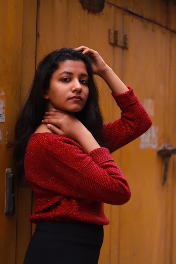 Woman in Red Long-sleeved Shirt Standing Beside Wall