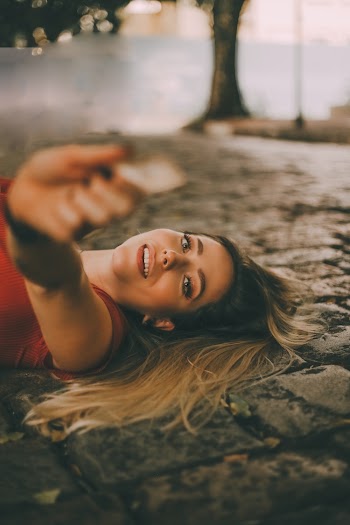 Woman In Red Lying On Cement Floor