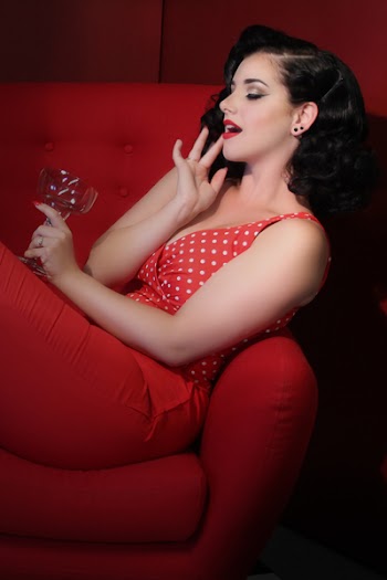 Woman in Red Outfit Lying on Red Couch While Holding a Cocktail Glass