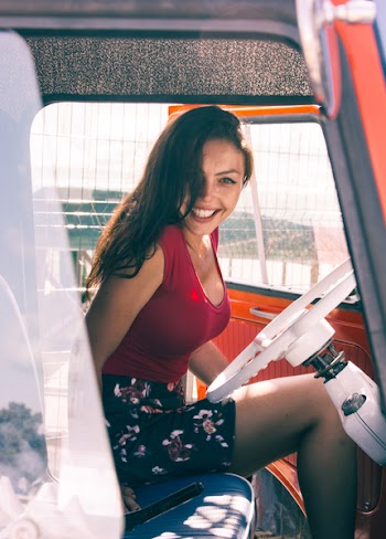 Woman in Red Shirt Sitting on Vehicle Seat at Daytime