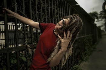Woman in Red Shirt Touching Her Hair