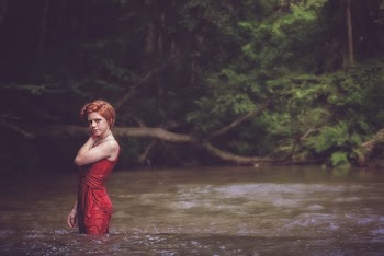 Woman in Red String Spaghetti Strap Dress on Body of Water Near Forest