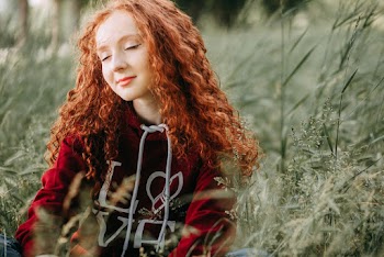 Woman in Red Sweater Sitting on Grass