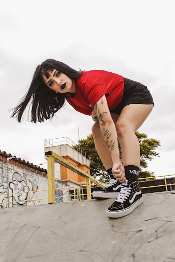 Woman in Red T-shirt, Black Short-shorts, and Black Vans Sk8-hi Sneakers