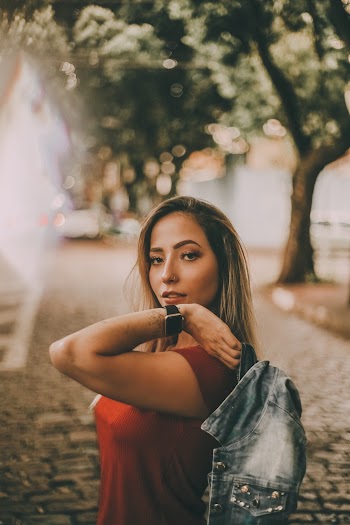 Woman in Red T-shirt Holding Black Faded Denim Jacket