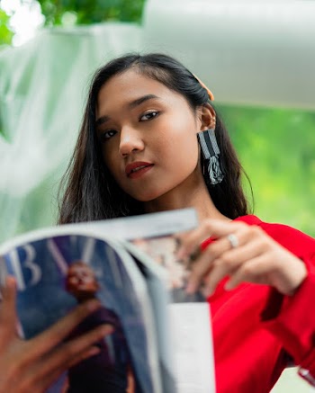 Woman in Red Top Reading Magazine
