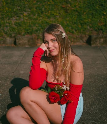 Woman in Red Tube Top Sitting on Pavement