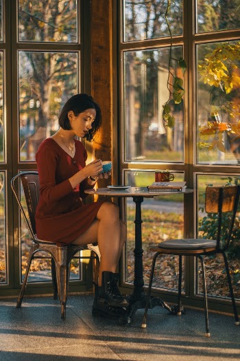 Woman in Red V-neck Long-sleeved Dress Sitting at Pub Set