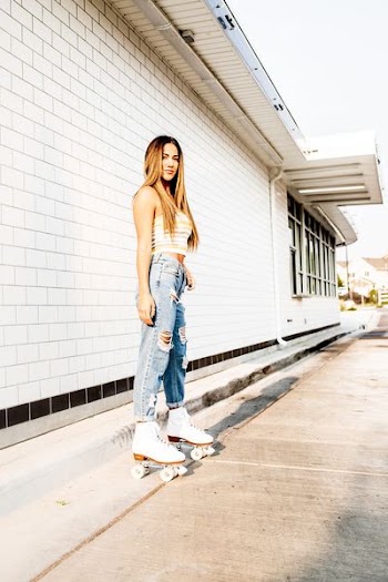 woman in roller skates standing outside of building near gutter