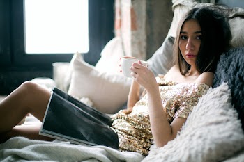 Woman in Sequinned Beige Off-shoulder Dress Laying on Bed