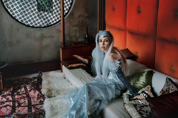 Woman in Silver Dress Sitting on Bed