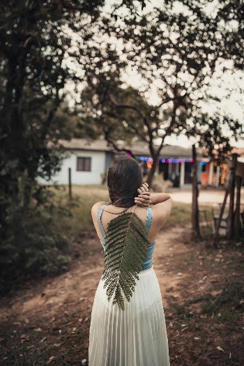 Woman in Sleeveless Dress Holding Large Leaf