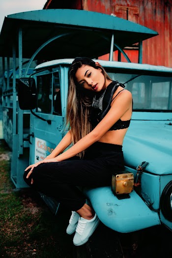 Woman in Sports Bra With Black Pants Sitting on White Truck