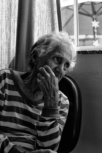 Woman in Striped Long-sleeved Shirt Sitting on Chair