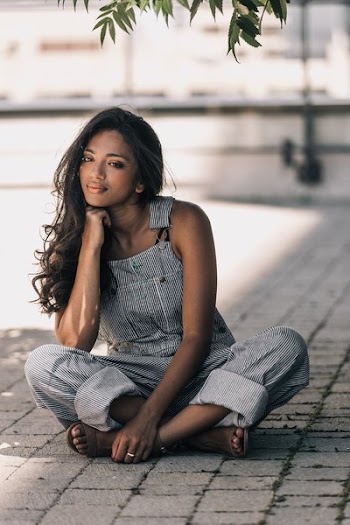 Woman In Striped Overalls Sitting Cross Legged