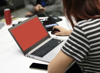 Woman in Striped Shirt Using Silver Laptop