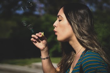 Woman in Striped Top Blowing Toy
