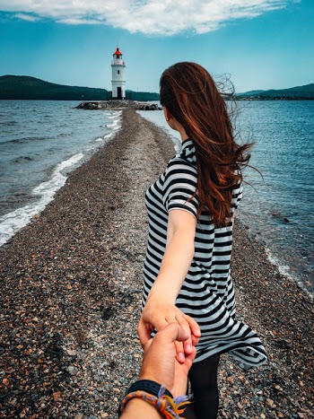 Woman in Stripes Holding Hands With Person Wearing Bracelets