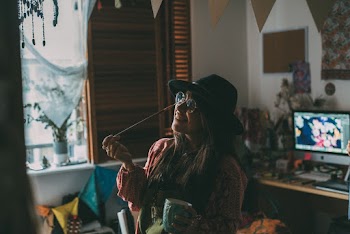 Woman in Sunglasses and Hat Holding Paintbrush