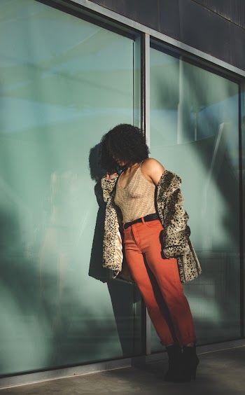 Woman In Tank Top And Pants Leaning On Wall