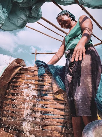 Woman in Teal Top Standing Beside Wicker Basket