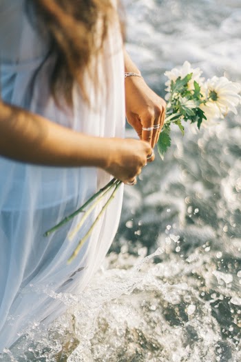 Woman In Water Holding White Petaled Flowers
