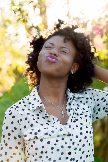 woman in white and black polka-dot top doing duck face