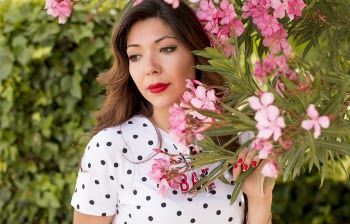 Woman in White and Black Polka Dots Dress Near Pink Flowers during Daylight