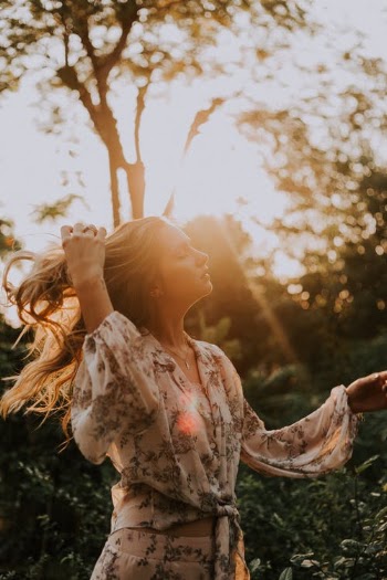 Woman in White and Red Floral Long Sleeve Shirt Covering Her Face With Her Hands · Free Stock Photo
